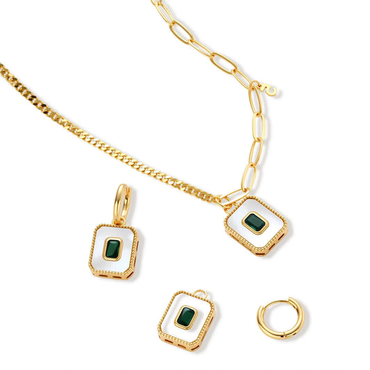 Gold-plated jewelry set with white enamel square pendants and emerald CZ stones on cream background.