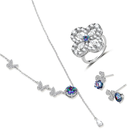 Sterling silver jewelry set with rainbow moissanite stones in clover and butterfly designs on cream background