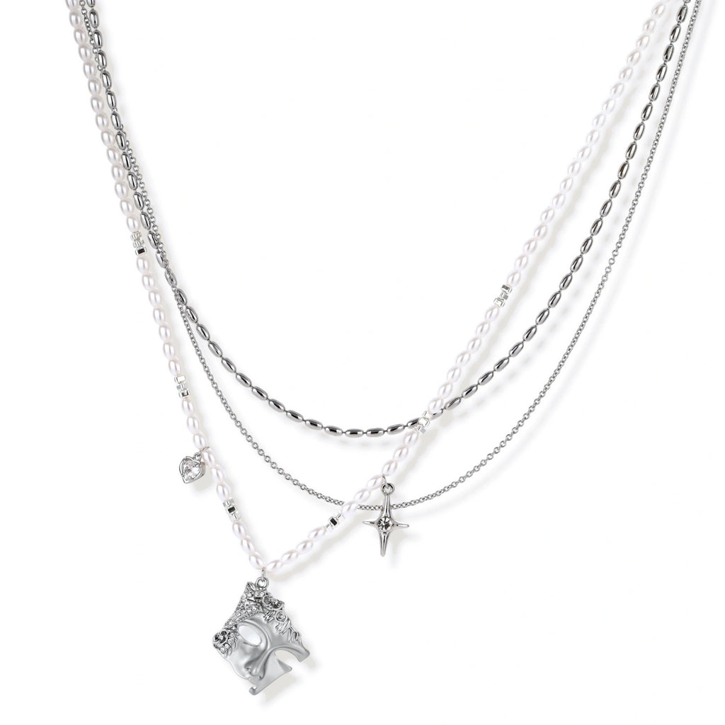Multi-strand layered necklace set with silver chains, white pearls, star charm, heart pendant, and ornate decorative piece