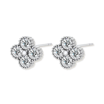 Dainty sterling silver quatrefoil stud earrings with four brilliant moissanite stones and center accent on white background.