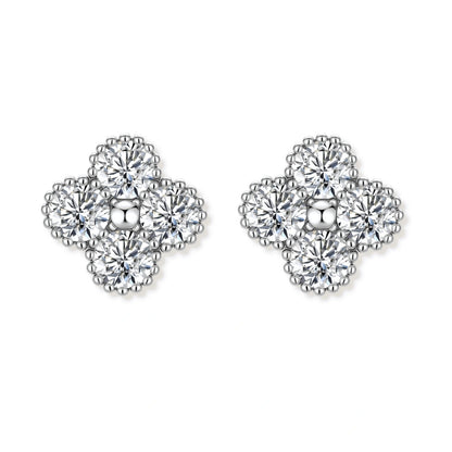 Dainty sterling silver quatrefoil stud earrings with four brilliant moissanite stones and center accent on white background.