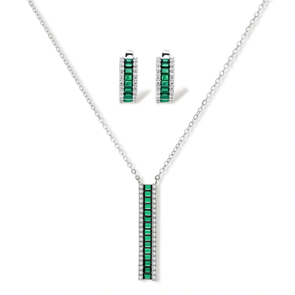 White gold plated jewelry set with emerald green rectangular stones and clear crystals in geometric rows on white background.