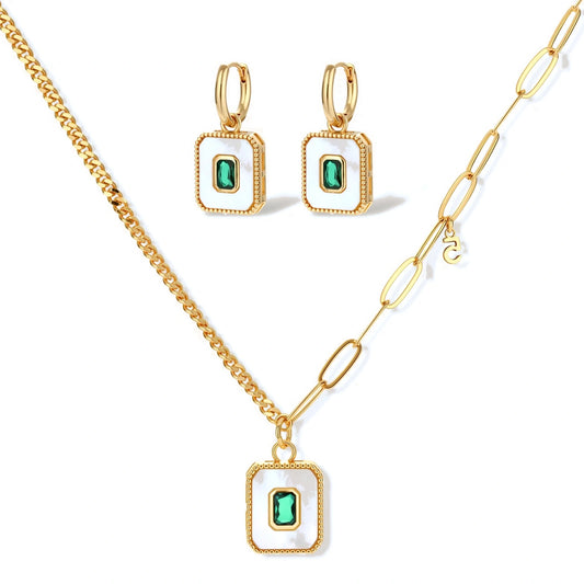Gold-plated jewelry set with white enamel square pendants and emerald CZ stones on cream background.