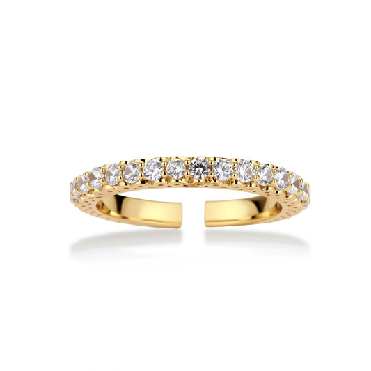 Close-up of adjustable gold-plated ring with continuous row of round zirconia stones on neutral background.