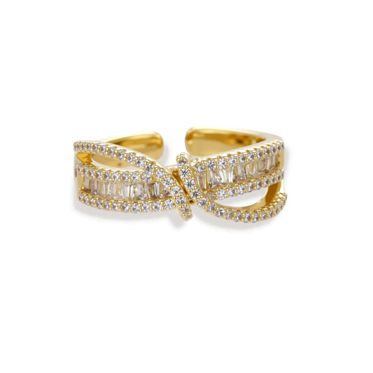 Close-up of gold-plated adjustable ring with crossing bands and sparkling zirconia stones on white background.